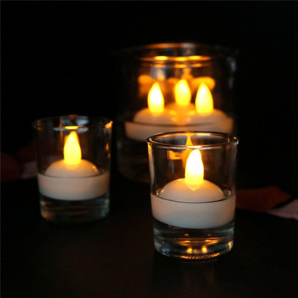 Set of floating LED tea light candles with warm yellow light in glass cups