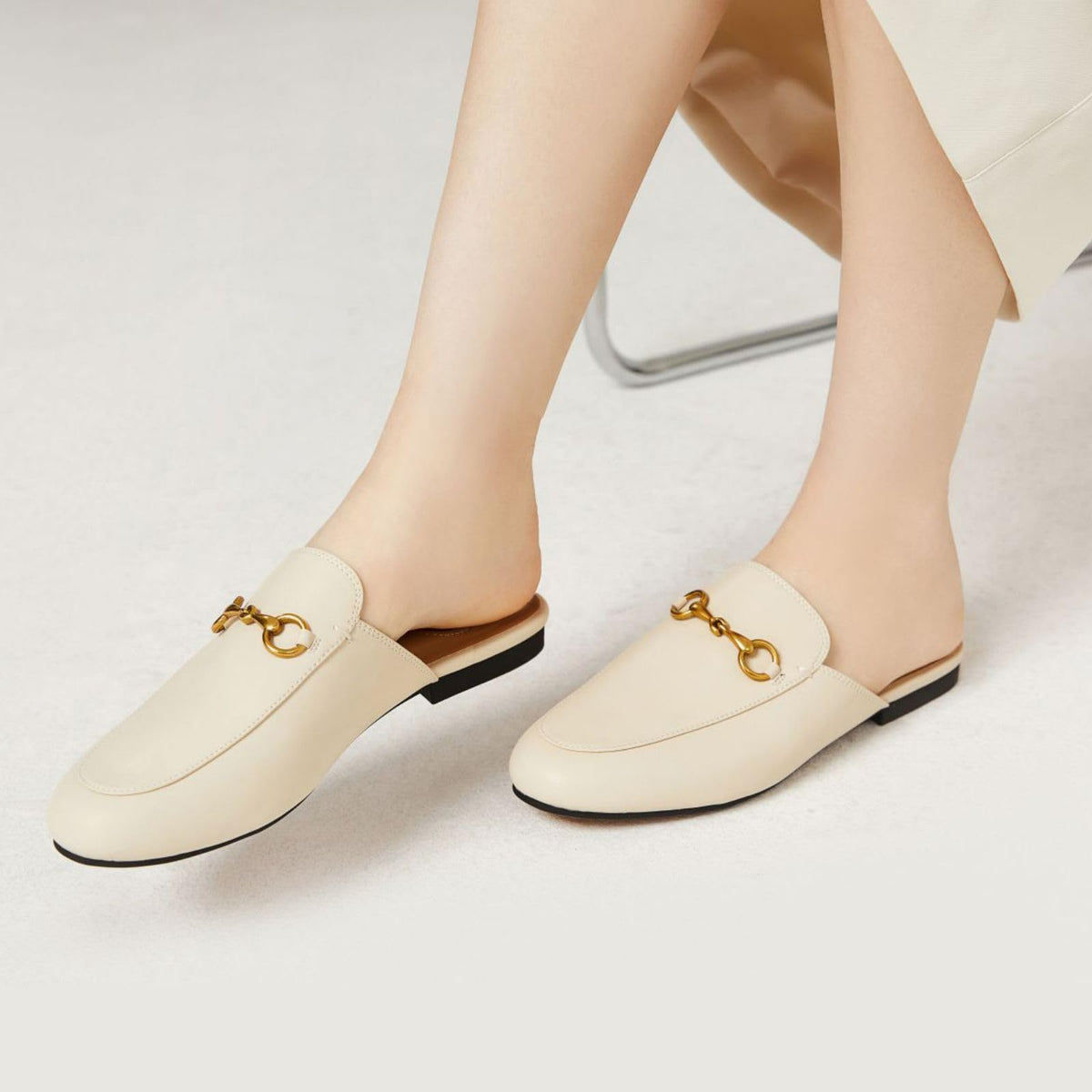 Ivory mule loafers, pair view, gold buckle detail, low backless slip-on heel