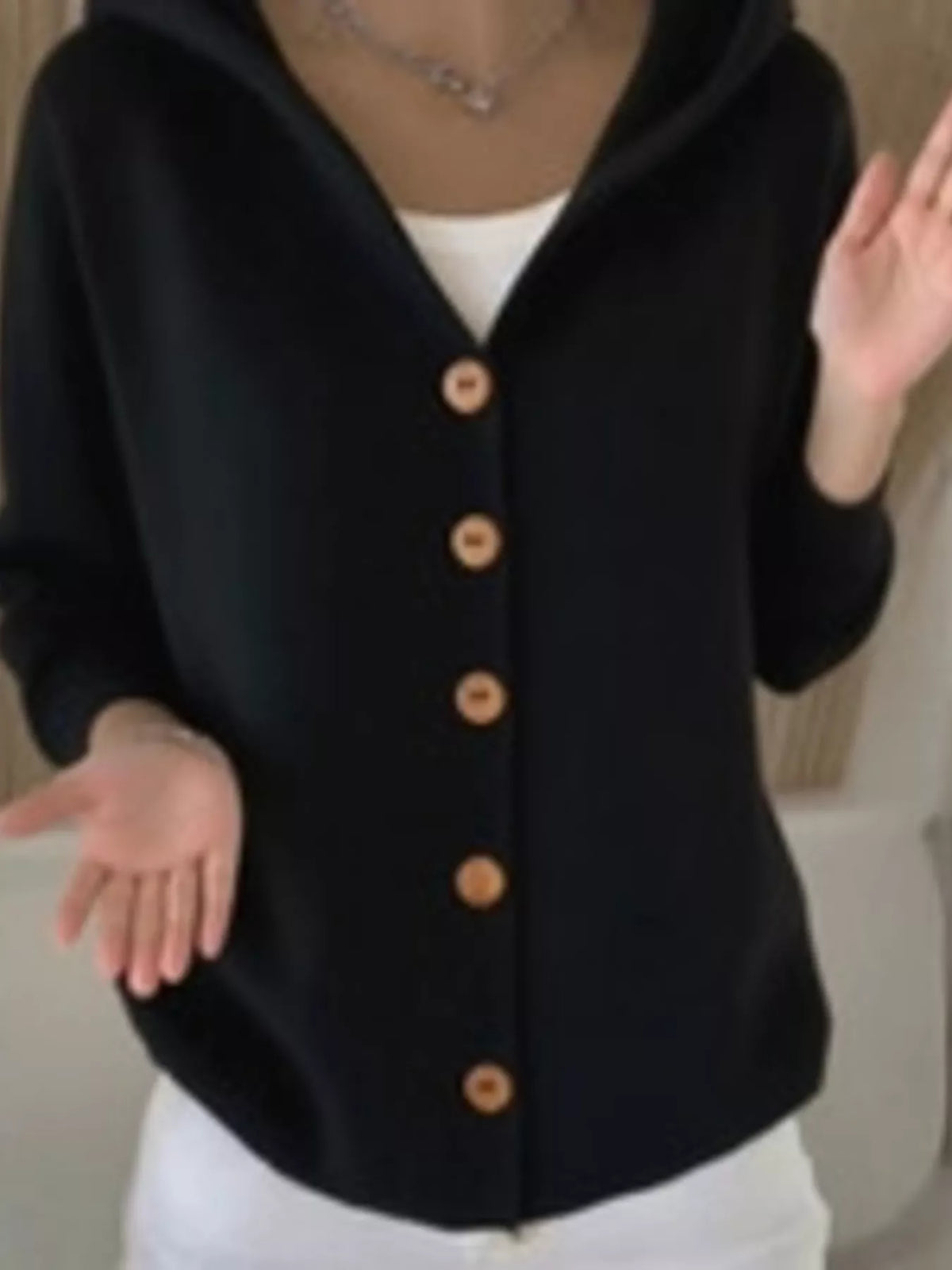 Black hooded knit cardigan with button-front closure and draped fit