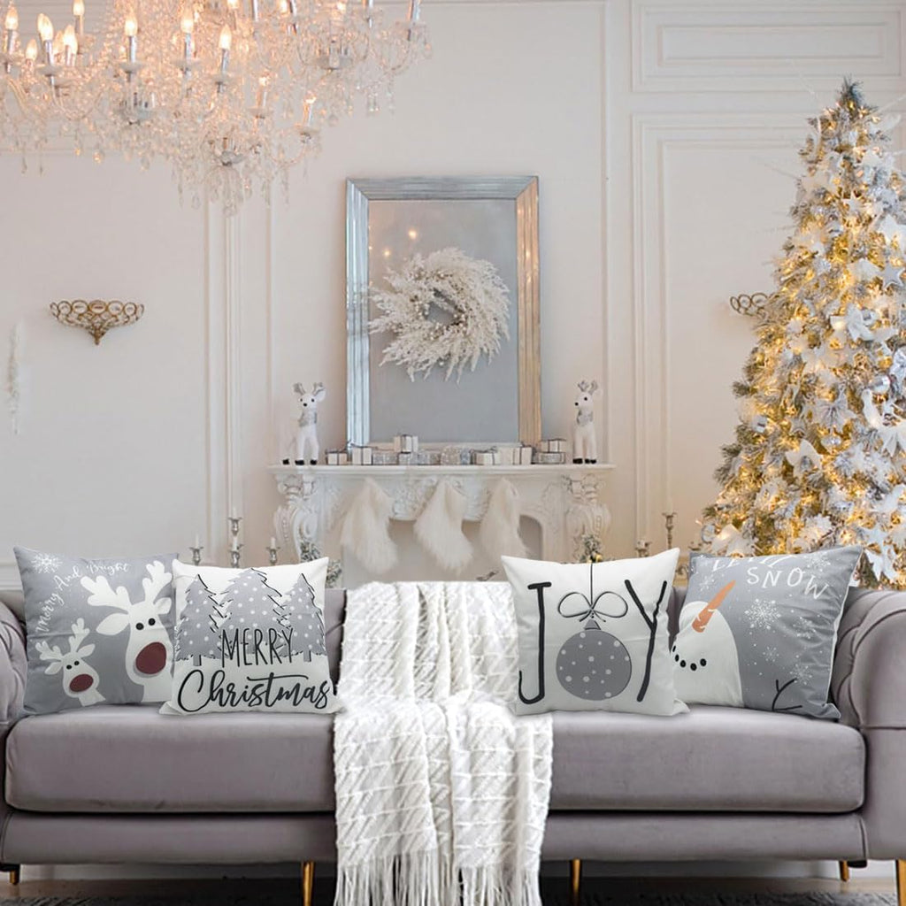 Christmas pillow covers on living room sofa with tree, snowman, Joy ornament and reindeer