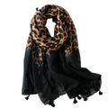 Leopard print scarf wrap with tassels and black solid border at one end.