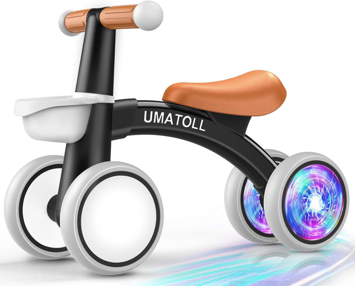Black and orange toddler balance bike with white wheels and glowing LED front wheel