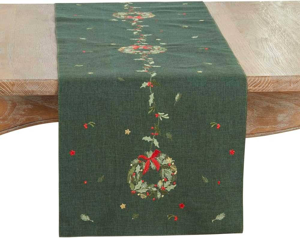 Green Christmas table runner with embroidered wreath and red bow centerpiece
