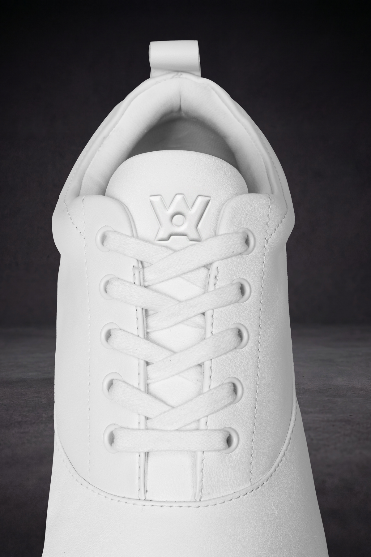 White lace-up sneaker upper with eyelets and WOA embossed emblem on tongue