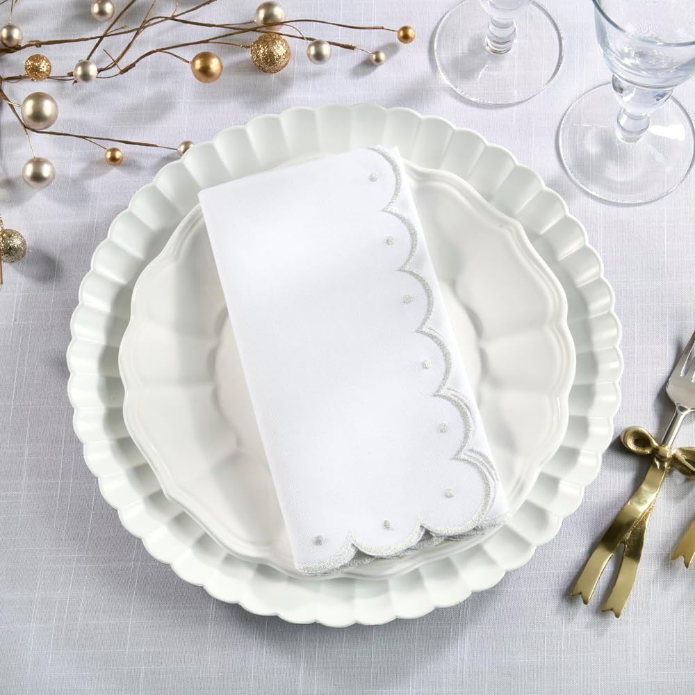 White embroidered scalloped cloth napkins set of 4 with gold trim, folded on plates