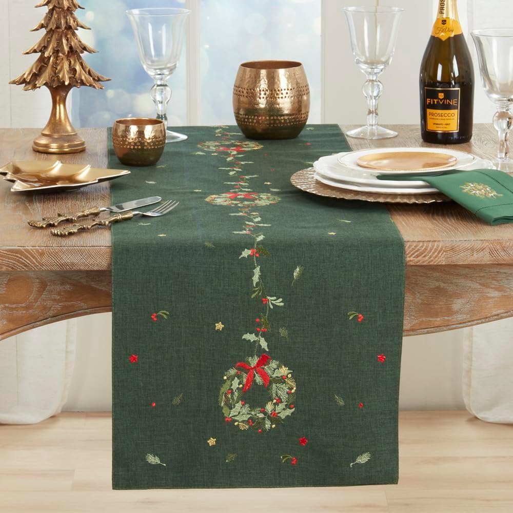 Green Christmas table runner with central embroidered wreath and red ribbon detail