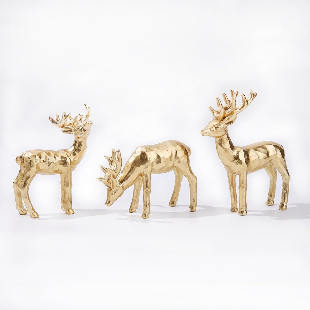 Three gold resin reindeer figurines, front view with raised antlers, tabletop set
