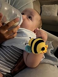 Close-up of baby with a bee wrist rattle and striped ladybug rattle socks