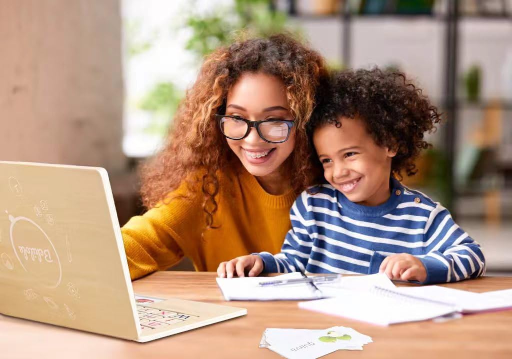 Adult and child using wooden learning laptop together with word cards