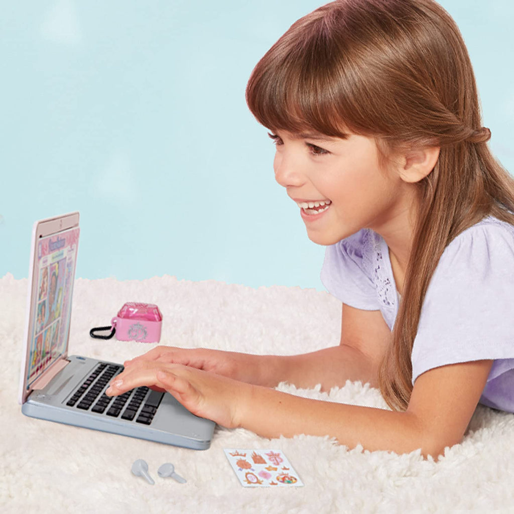 Kids laptop on a soft surface with open screen and black keyboard, accessories scattered