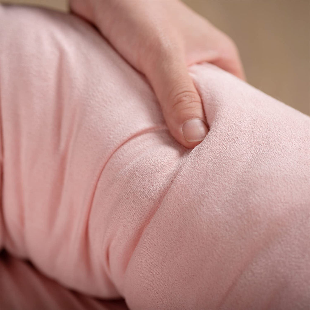 Close-up of pink fabric on a plush pet bed cushion, showing a soft padded surface.