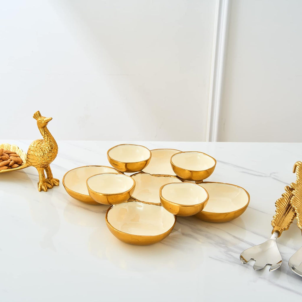 Cluster of 9 round gold and white serving bowls arranged on a tabletop