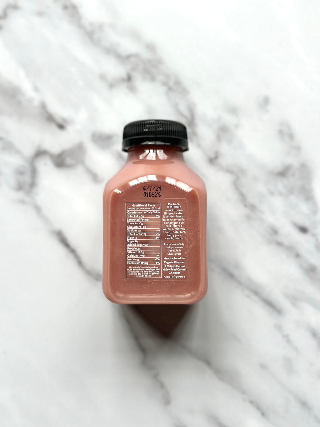 Organic Pharmere Relax beverage bottle, rear label text visible, amber pink, black cap.