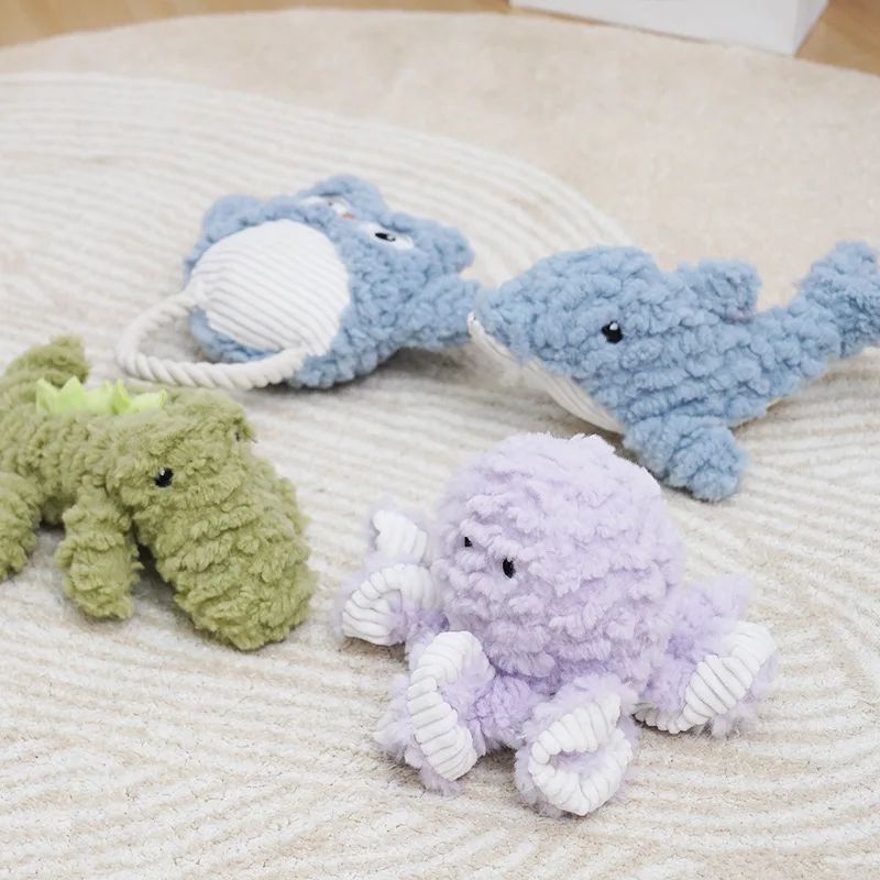 Assorted corduroy plush dog toys in blue, lilac, and green with striped bellies