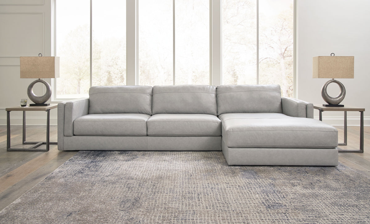 Light gray sectional sofa with corner chaise, square ottoman-like cushion, and pillows