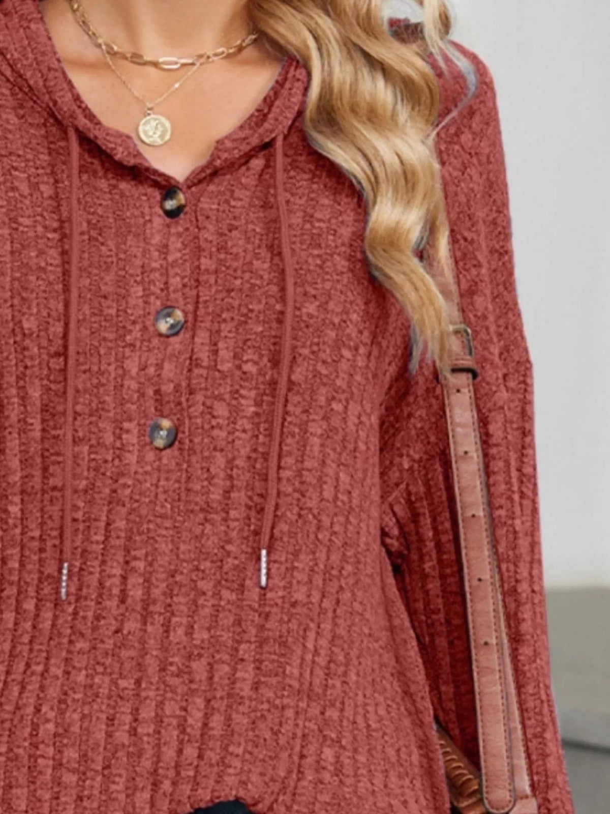 Rust red ribbed knit hoodie neckline with hood drawstring and button placket.