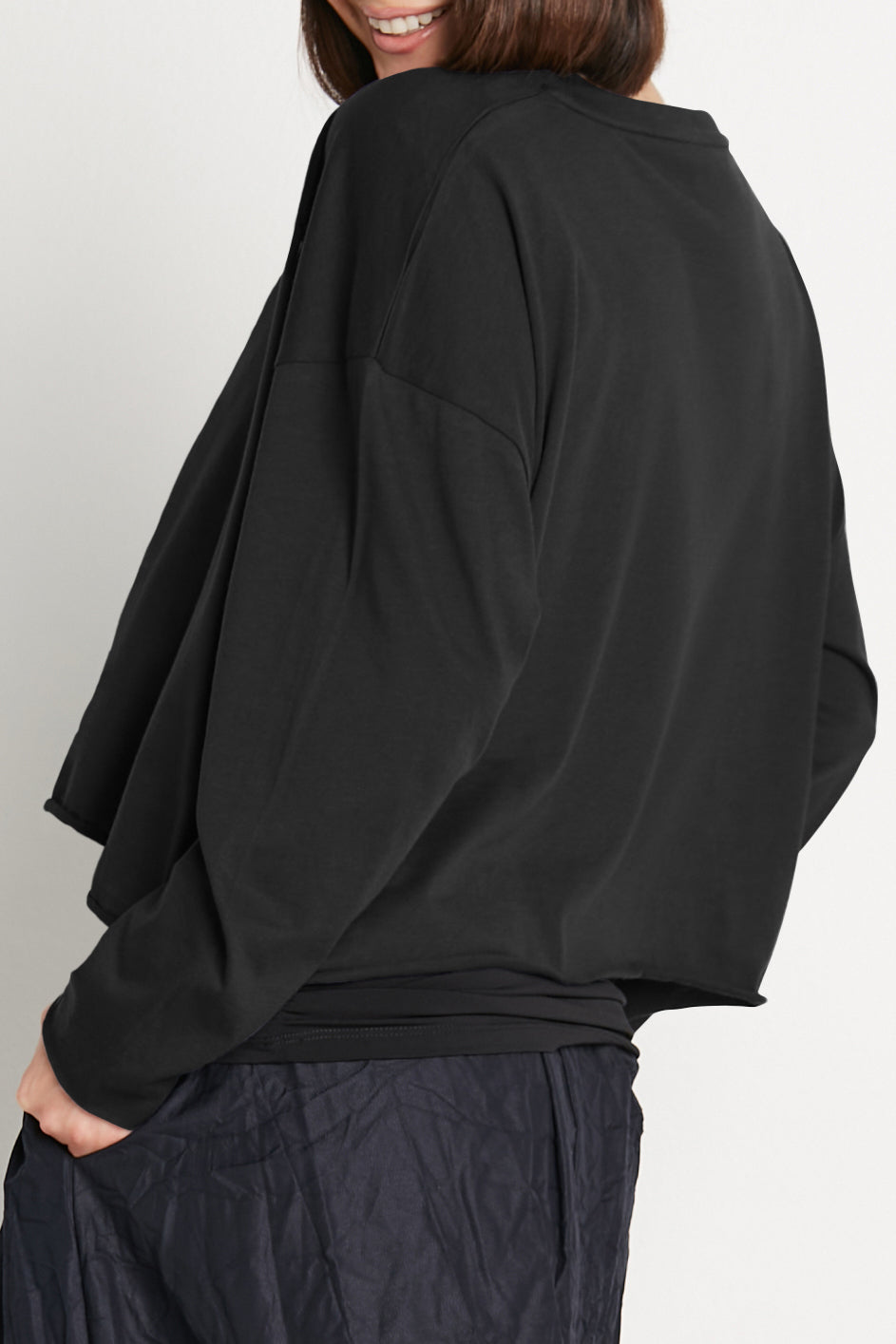 Black boxy long-sleeve T-shirt, side view with relaxed shoulder and sleeve