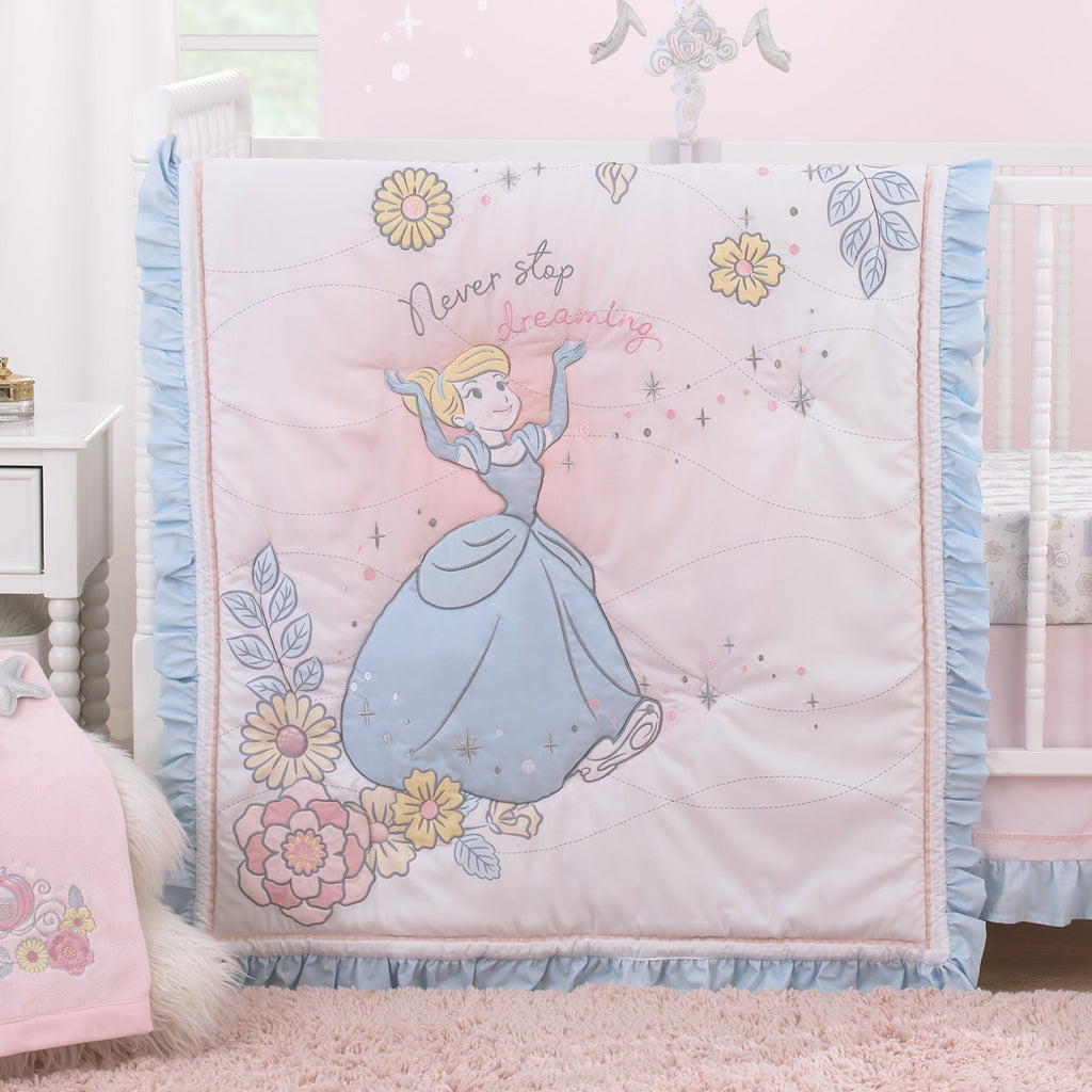 Light blue ruffled comforter with princess and floral print on crib bedding