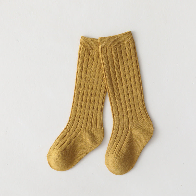 Pair of mustard yellow mid-calf ribbed baby socks.