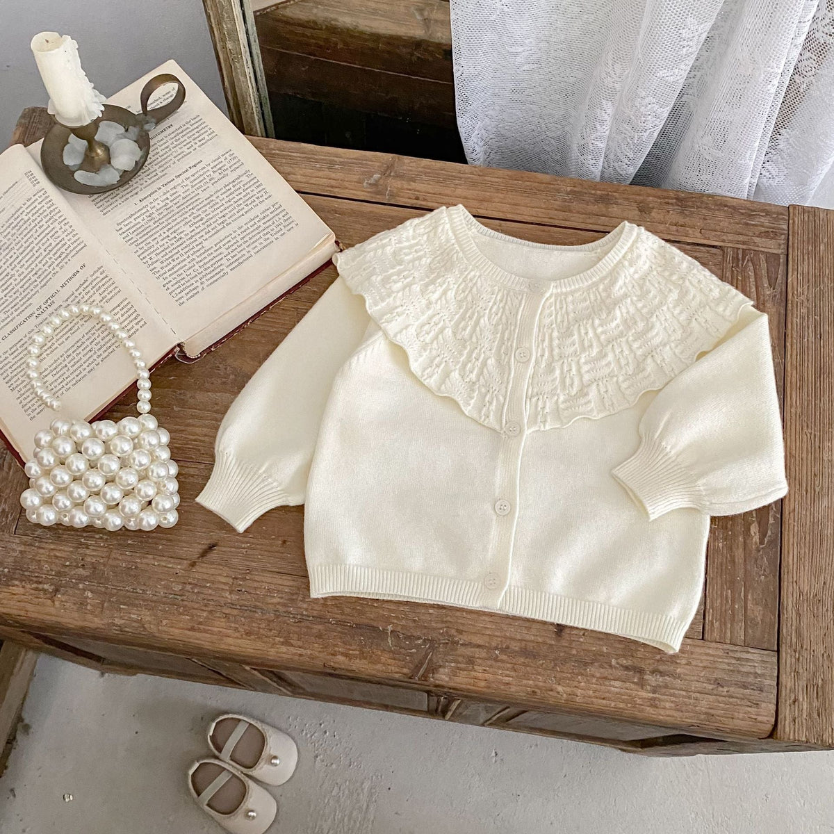 Cream baby knitted coat with wide ruffled lapel and button-front, long sleeves