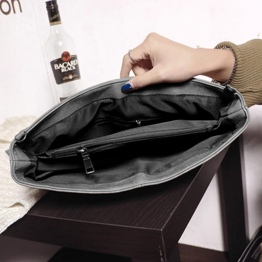 Open black leather clutch purse interior with zip pocket and stitched lining
