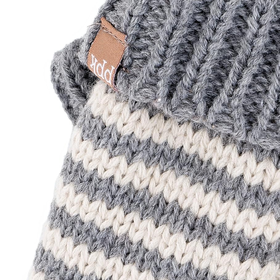 Close-up of grey knit striped mitten with leather brand tag near cuff