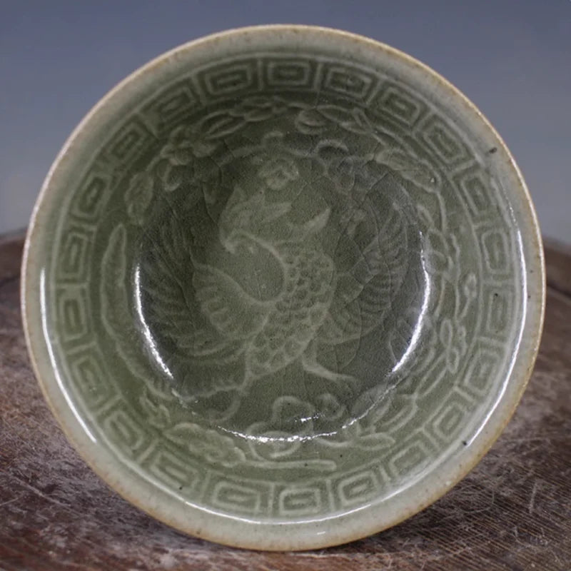 Celadon porcelain bowl top view with raised phoenix and border pattern