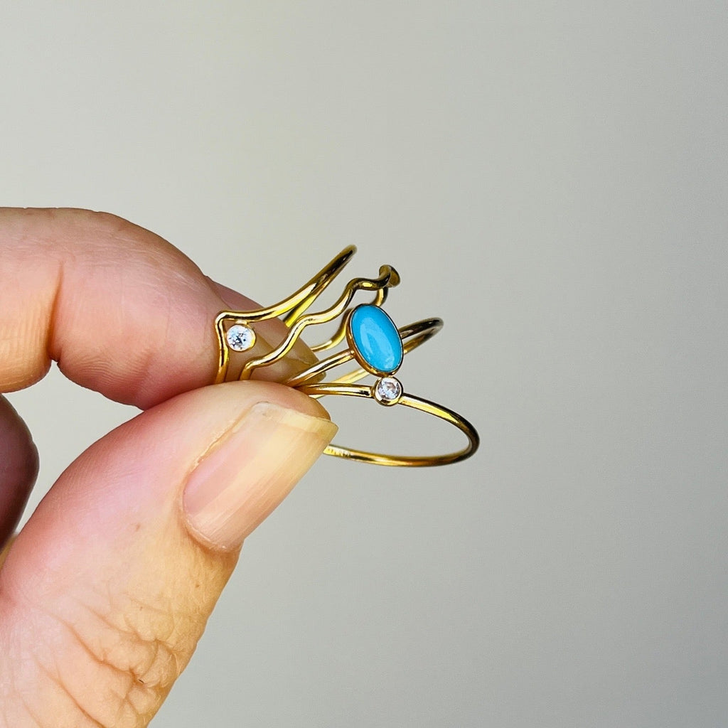 Gold-tone open wave ring with oval turquoise cabochon and small clear stones