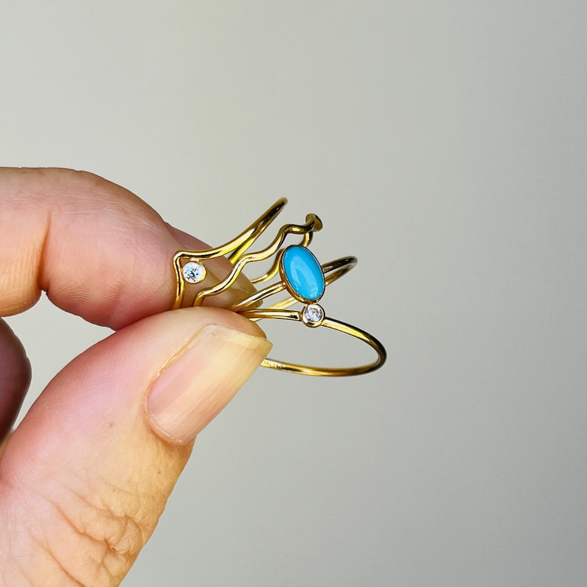 Gold-tone open wave ring with oval turquoise cabochon and small clear stones