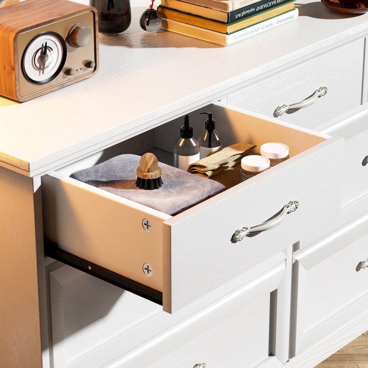 White dresser with open drawer showing organizer contents, gold metal pull