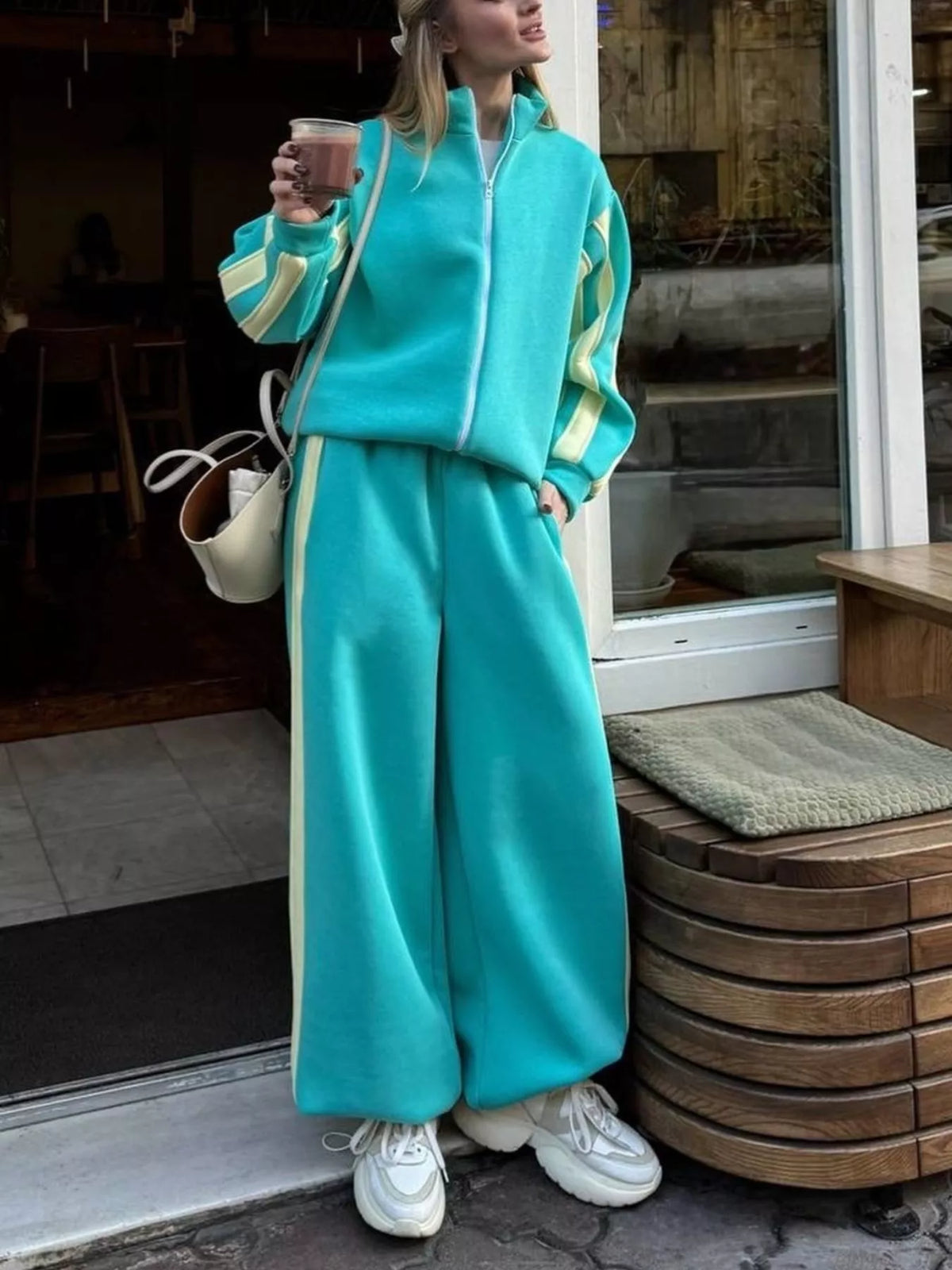 Teal contrast-striped zip-up top and wide-leg pants set with zipper front and side stripes.