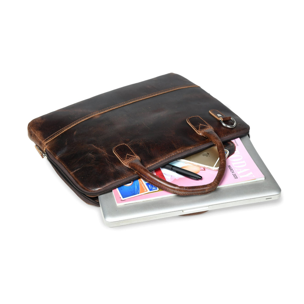 Dark brown leather laptop bag resting on a laptop with documents inside