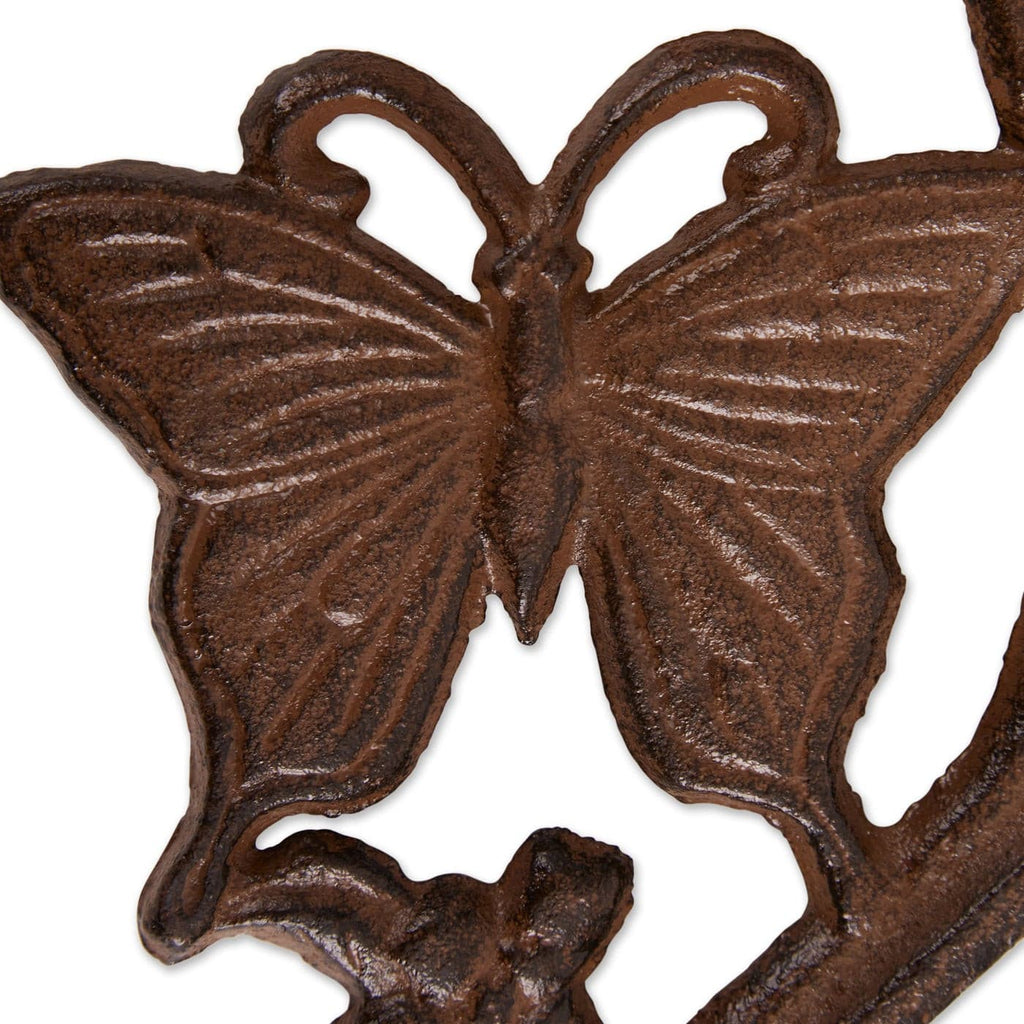 Close-up cast iron planter bracket with detailed butterfly relief and leaf accents