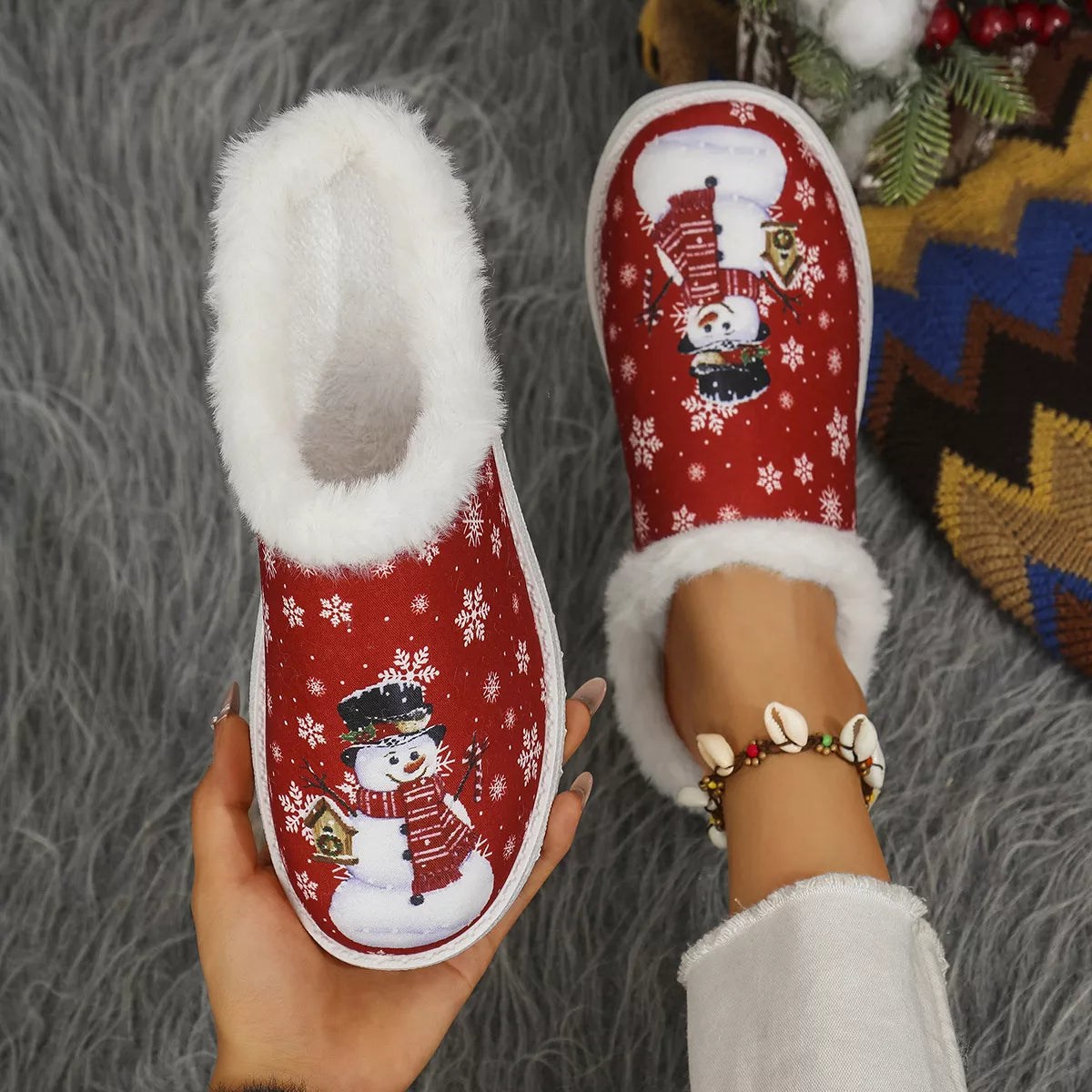 Red Christmas plush slippers with snowman graphic and white faux-fur lining