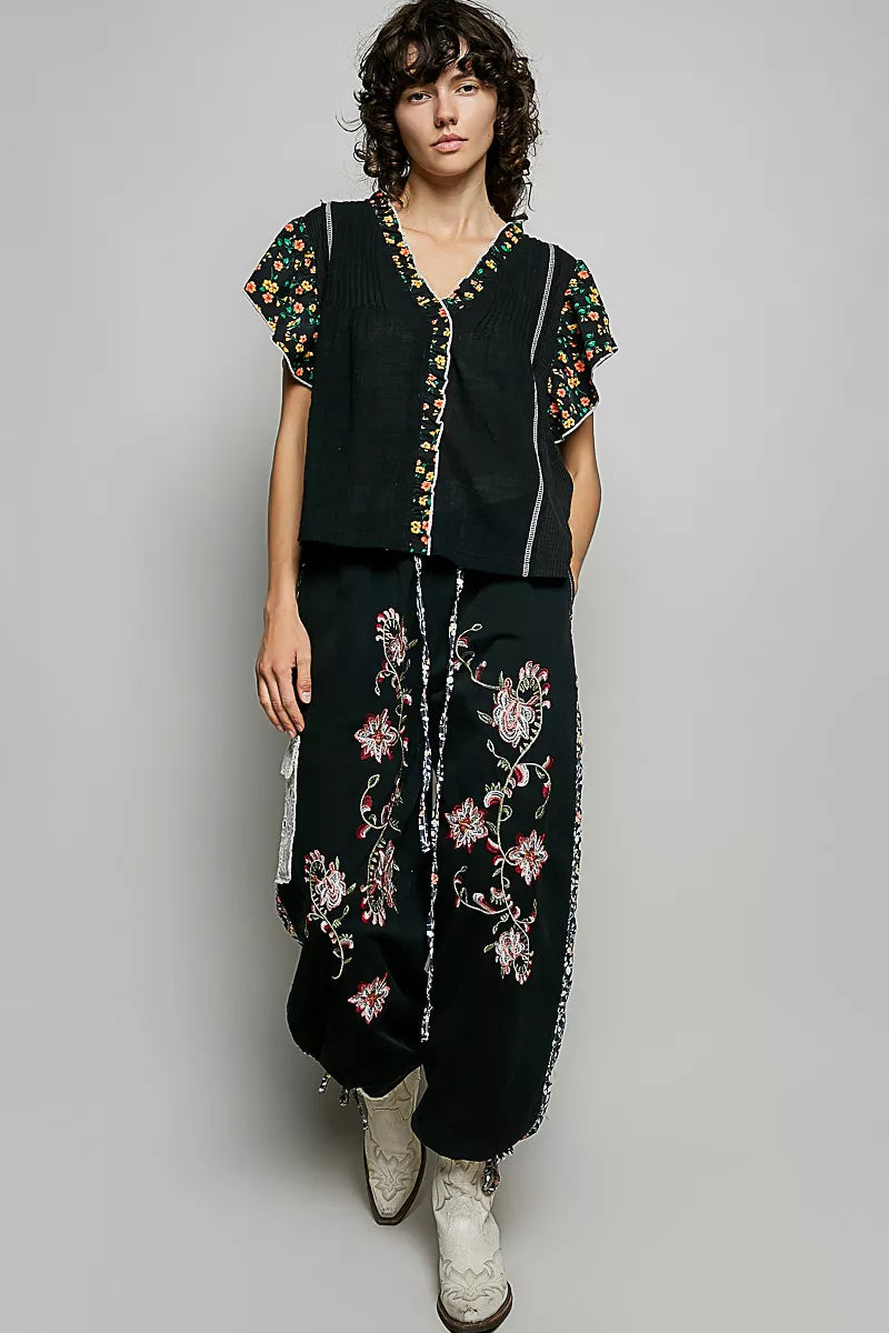 Black V-neck floral ruffle sleeve blouse with button front and floral embroidered accents