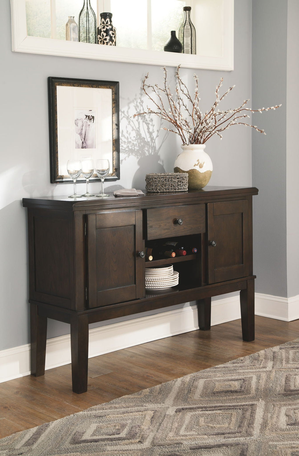 Dark brown sideboard cabinet with open storage and matching dining chairs nearby