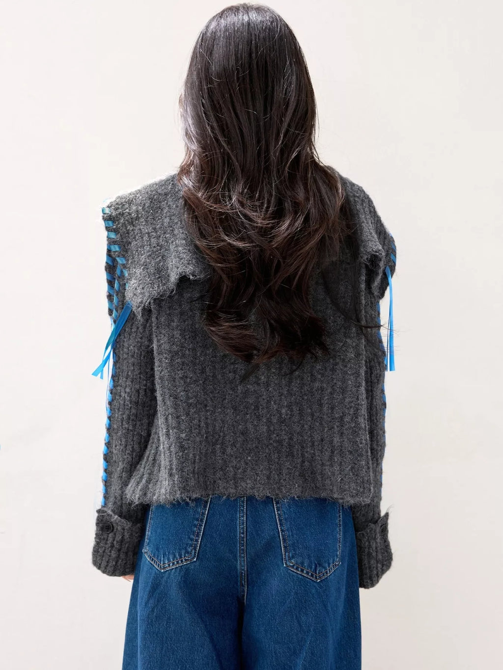 Gray ribbed knit open-front cardigan back view with blue trim and tie details