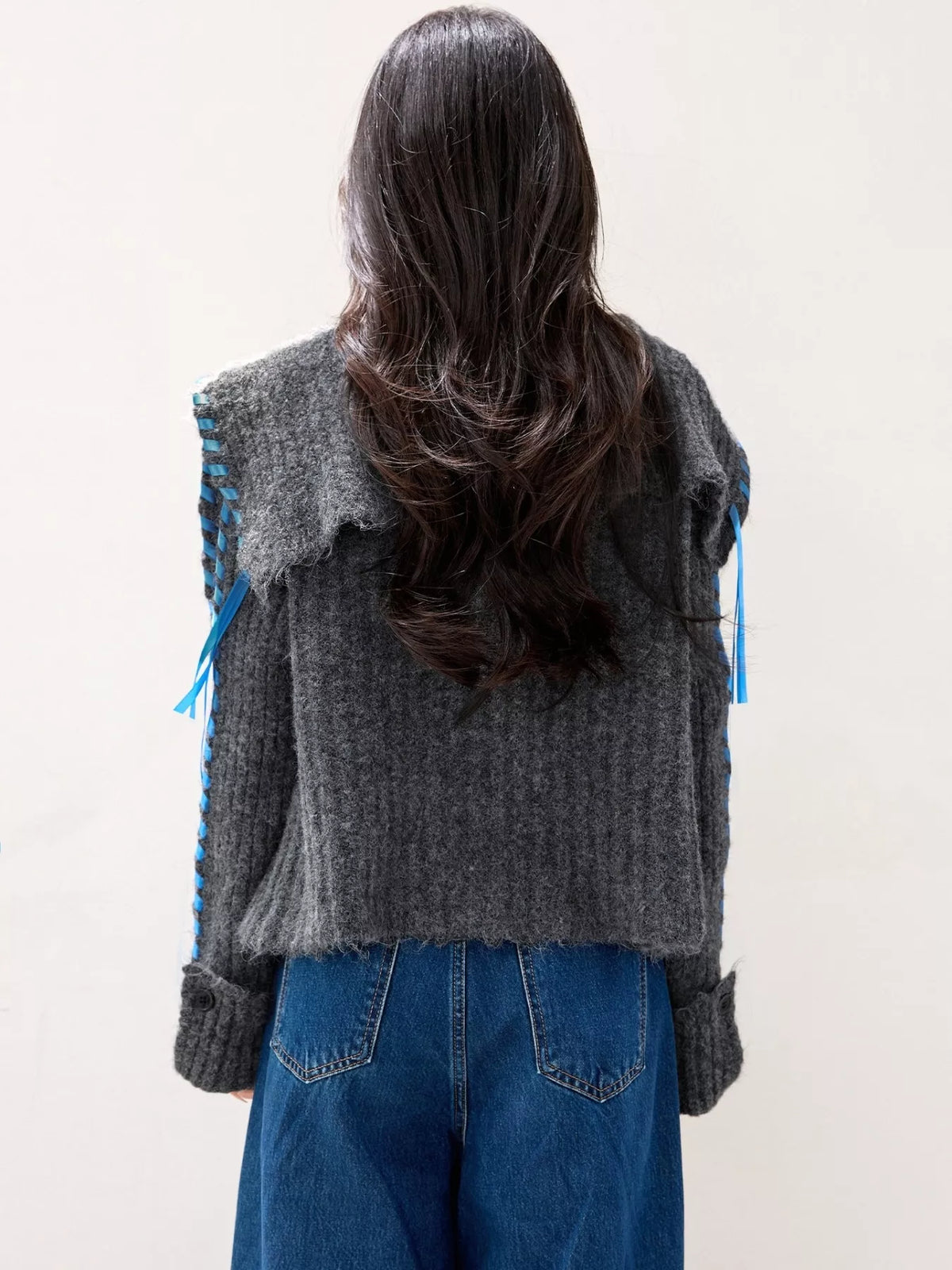 Gray ribbed knit open-front cardigan back view with blue trim and tie details