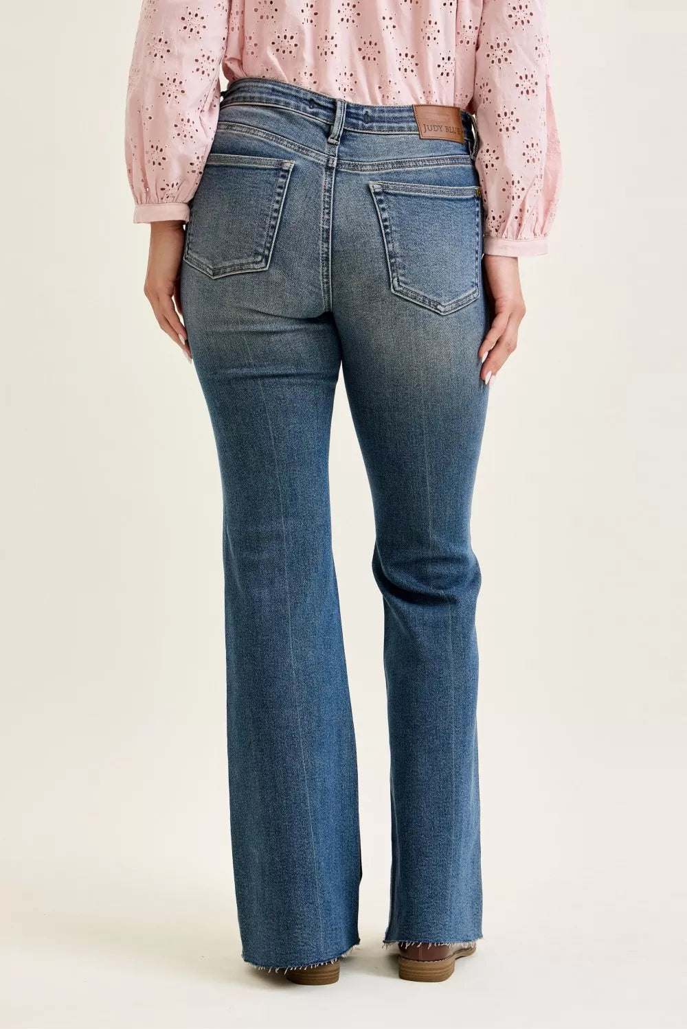 Mid-rise blue flare jeans with two front flap pockets and belt loops