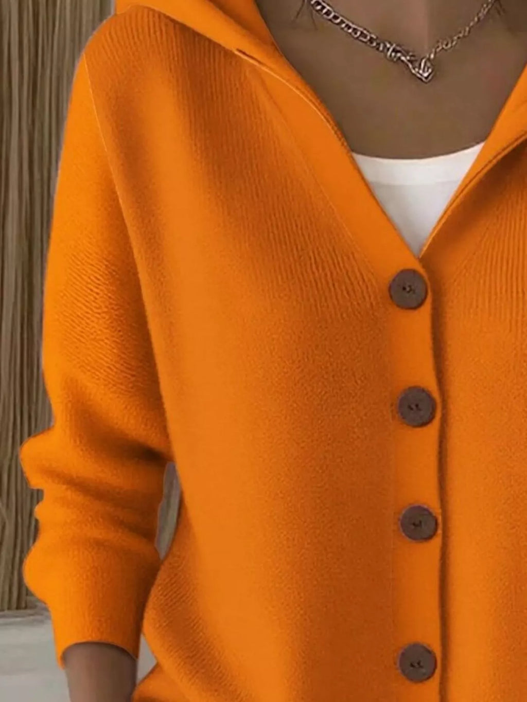 Orange hooded cardigan with V-neck, front buttons, and long sleeves in soft knit
