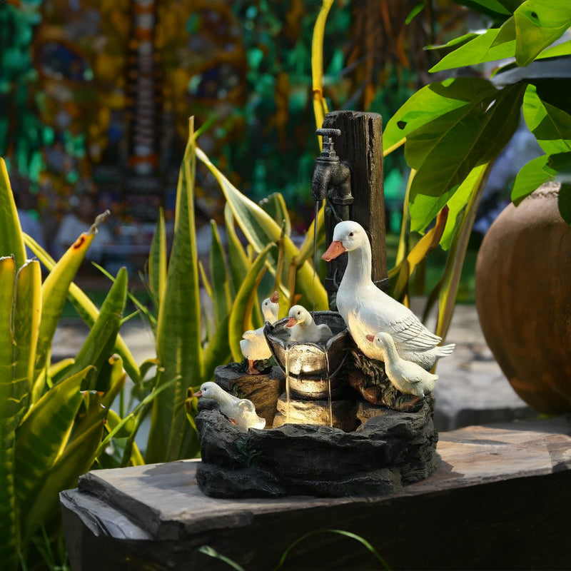 Resin garden fountain featuring white ducks, squirrels, and stacked water bowls