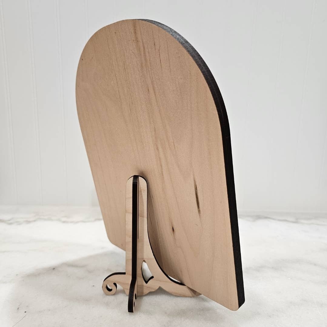Arched framed art panel with fold-out metal easel stand and black-edged backboard