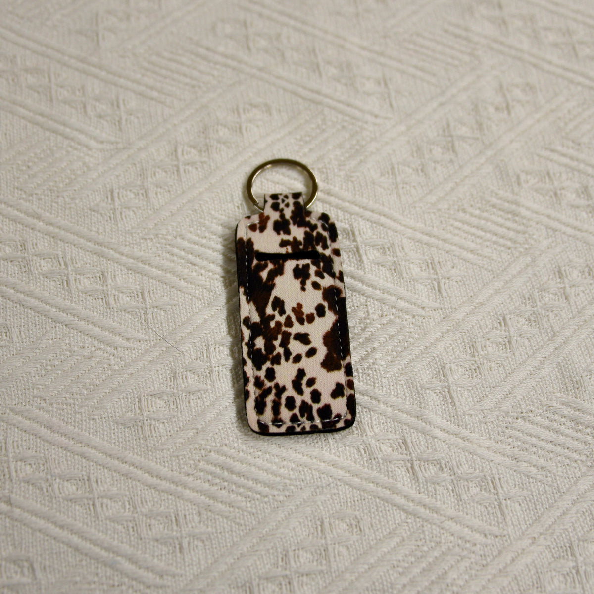 Leopard-print chapstick holder keychain with gold-tone key ring