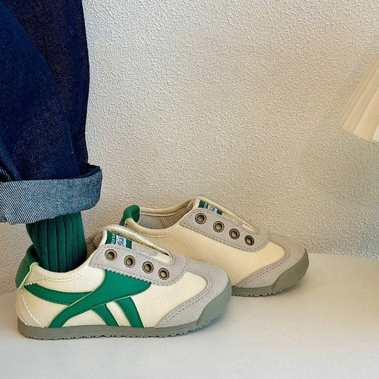 Kids casual sneakers with white uppers and green side stripes, paired with light beige sneakers.