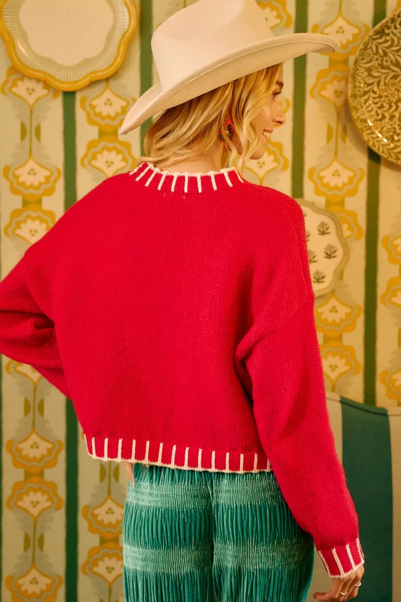 Red knit sweater back with white fringe hem and neckline trim