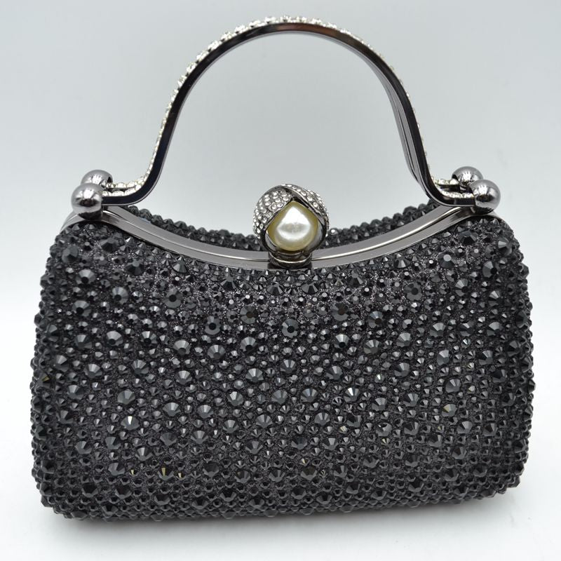 Black rhinestone evening clutch with pearl clasp and curved metal handle