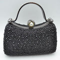Black rhinestone evening clutch with pearl clasp and curved metal handle