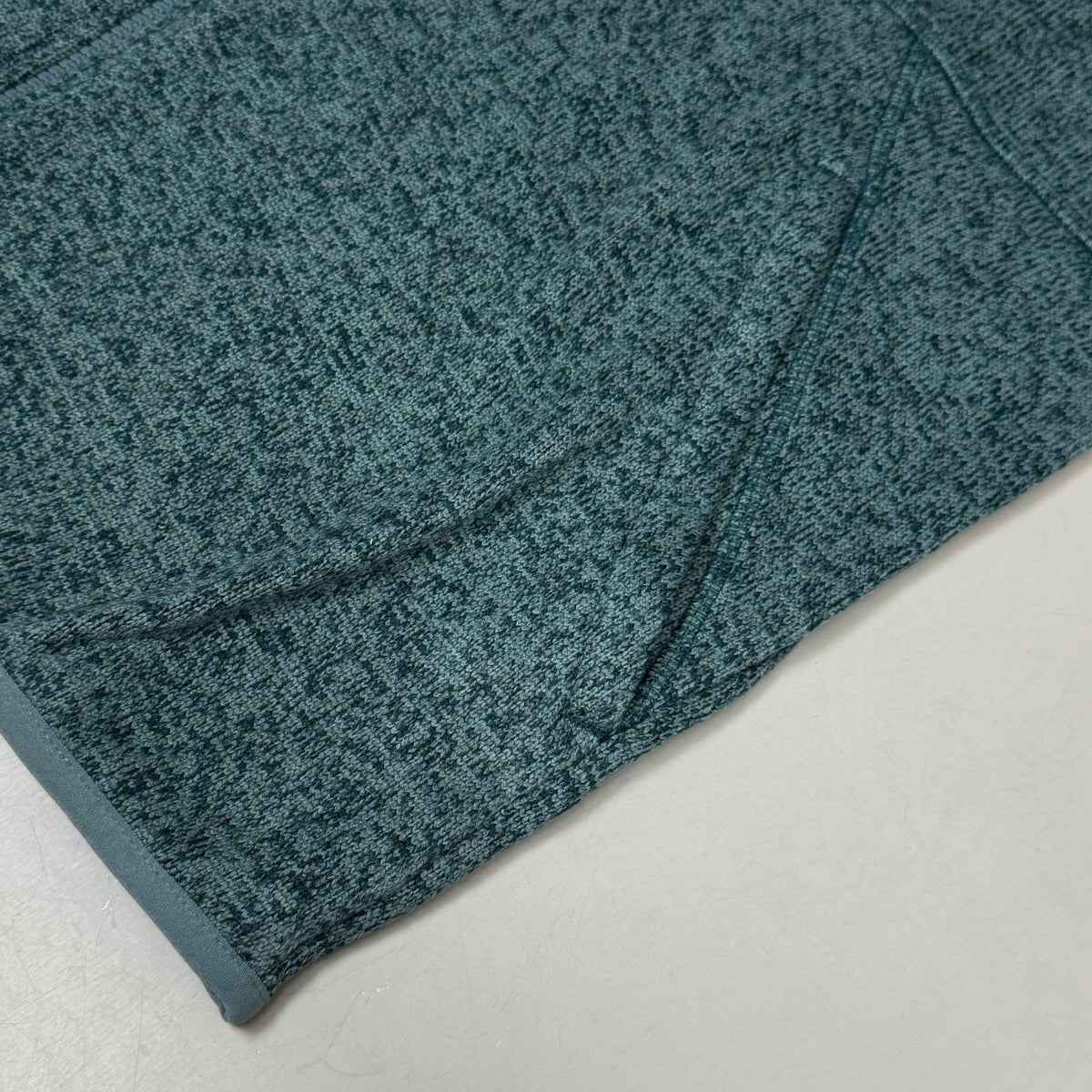 Men's heather teal fleece jacket sleeve and hem with knit texture