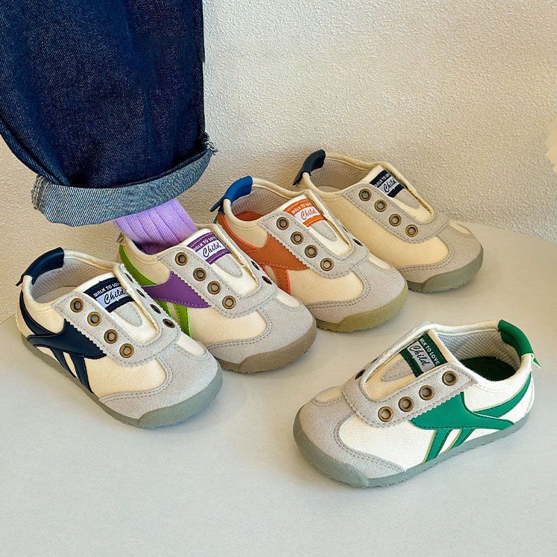 Kids casual sneakers with white uppers, showing purple, green, and blue side stripe details.