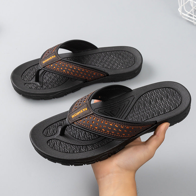 Men's black flip-flop sandals with orange perforated strap, one hand holding the pair
